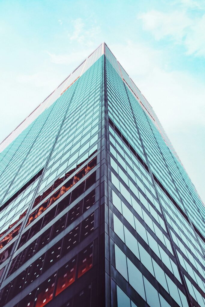 Low angle view of a modern skyscraper in New York City showcasing architectural design against a clear sky.
